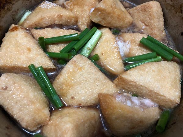 將釀好的三角豆腐放進鍋中，加入調味醬汁跟蔥段，水滾後轉小火煮約30分鐘即可
