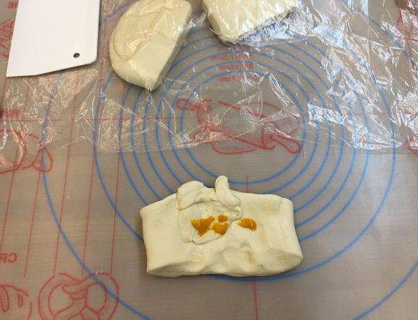 以三桿三折方式讓麵糰表面光滑，接著分割麵團

用水將食用色素粉混開，再拌入麵團以洗衣服的手勢讓麵糰染色