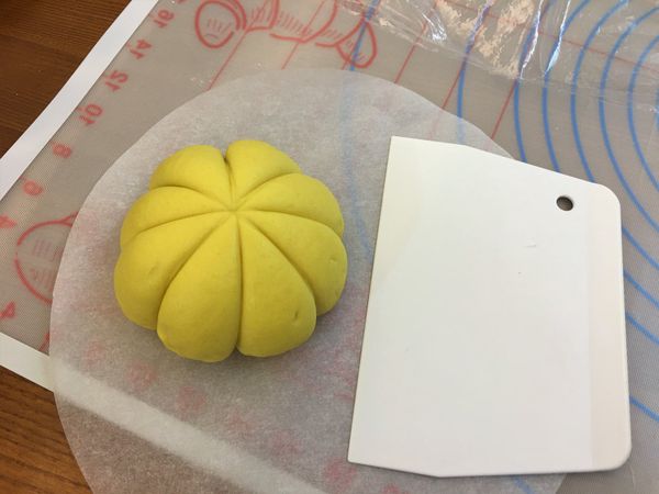 將麵團桿成圓形後包入棗泥餡，將麵團收口滾圓

以刮板壓出南瓜紋路