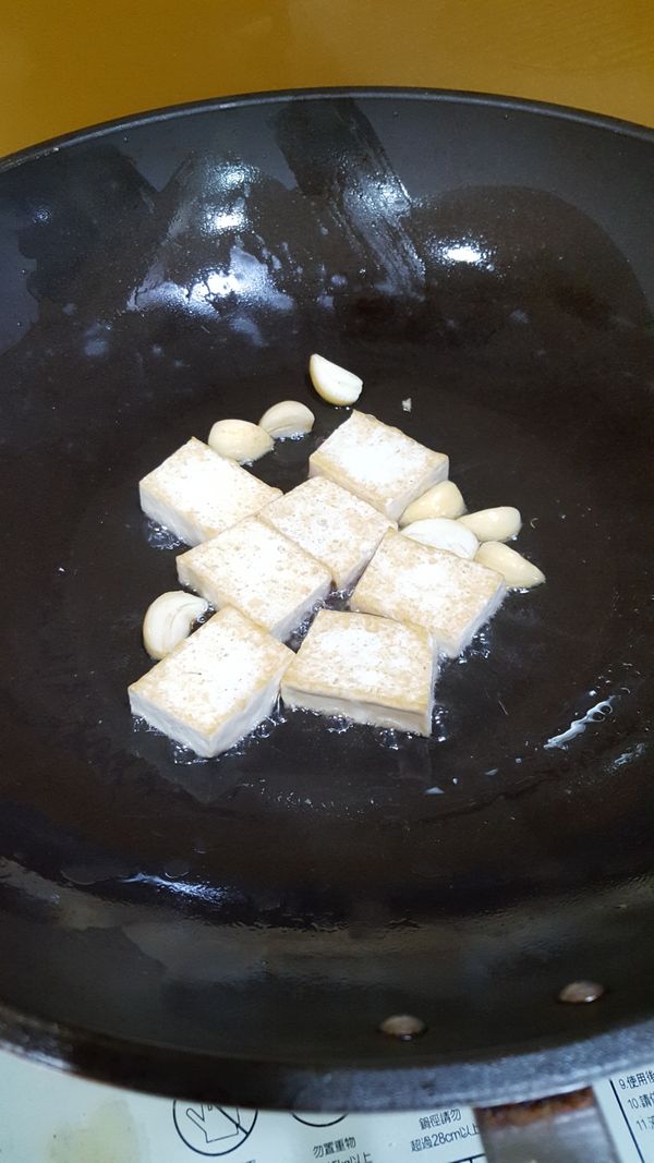豆腐切厚片煎到稍微金黃放入蒜頭爆香