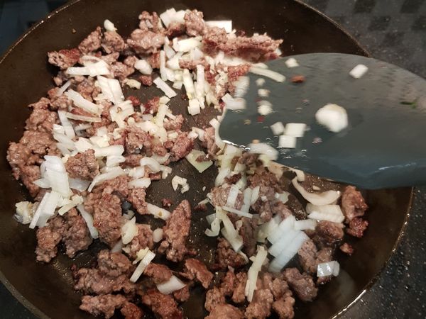 轉小火，洋蔥和大蒜下鍋炒出香味。