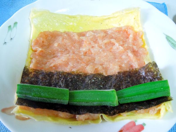 將雞肉慕斯泥鋪平在蛋皮上，秋葵包裹著海苔，放在雞肉慕斯泥上，如壽司般包捲起來，蛋皮接口抹少許太白粉黏合。