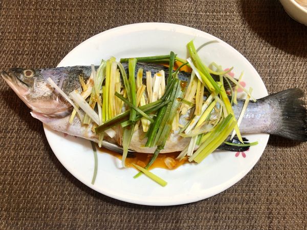 鱸魚洗淨，身上劃個2-3刀，抹上薄鹽，薑片3片切絲，蔥切小段，舖在魚身上，將調味料淋上去