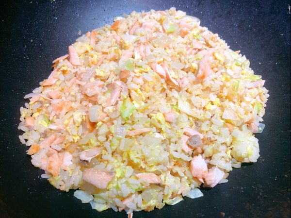 高麗菜稍拌炒後放入飯，炒致蛋八分熟後加入鮭魚與鹽（要不要加味精看個人哦！因為家裡有小孩都沒有再添加味精）