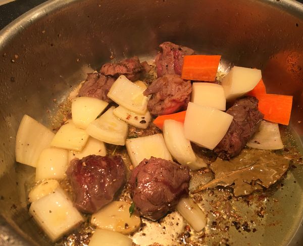 加入月桂葉、馬鈴薯、紅蘿蔔拌炒入味。