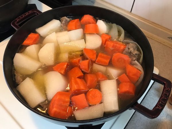 加入紅、白蘿蔔，中大火煮滾後，小火蓋鍋蓋燜煮20分鐘，此時可加入牛番茄(可省略)續燜煮10分鐘，加入適量鹽調味，熄火！