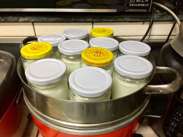 電鍋外鍋倒入1米杯水煮開後切到保溫，鮮奶加蓋後移至電鍋上