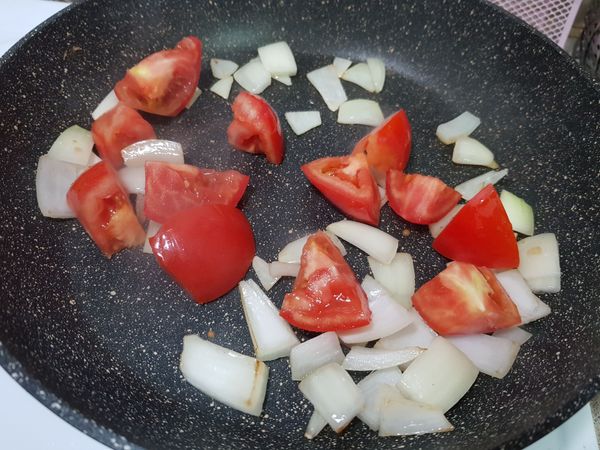 原鍋熱鍋，下一大匙小磨坊蒜風味油，放入洋蔥炒至邊緣透明後，放入蕃茄塊。
