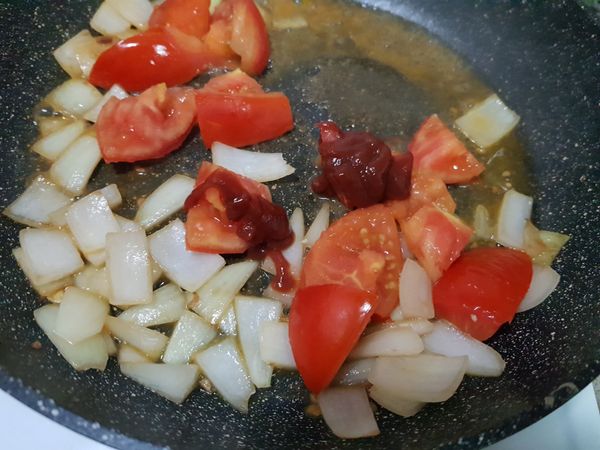 加入1/2碗水，放入一大匙蕃茄醬，1匙糖，1/3紅匙鹽巴，燉煮至蕃茄塊軟化。