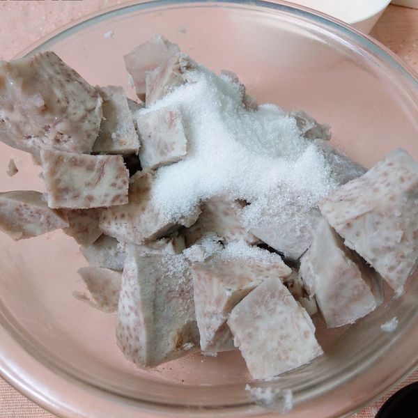 將蒸好的芋頭塊倒入盆中,趁熱將細砂糖倒入拌勻(趁熱氣將砂糖拌融化)