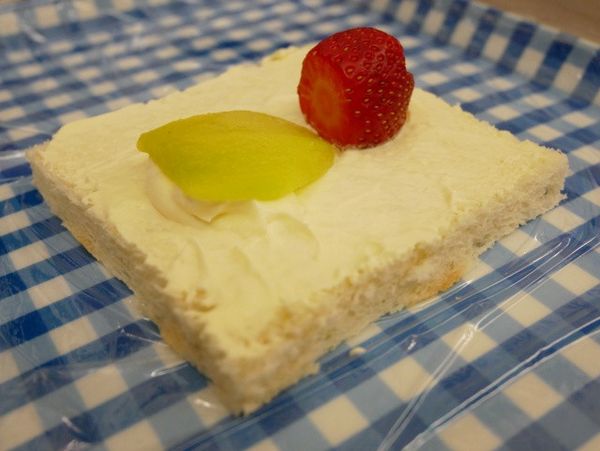 吐司先抹上奶油後中間擺上草莓及一片奇異果（葉子）下方補些許鮮奶油。