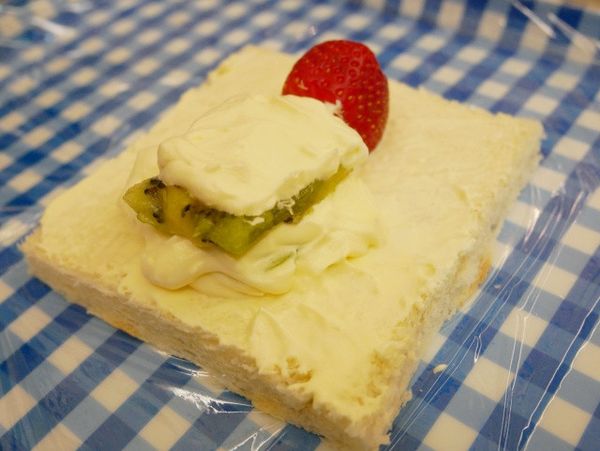 接著鋪上些許鮮奶油放上一片方形奇異果（莖）後鋪上鮮奶油。