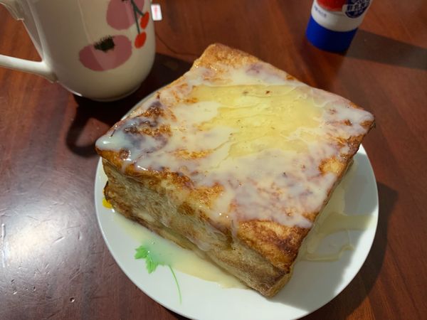 切薄薄奶油塊在吐司上並擠上煉乳