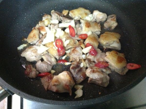 雞肉焦香後加蒜片和辣椒拌炒