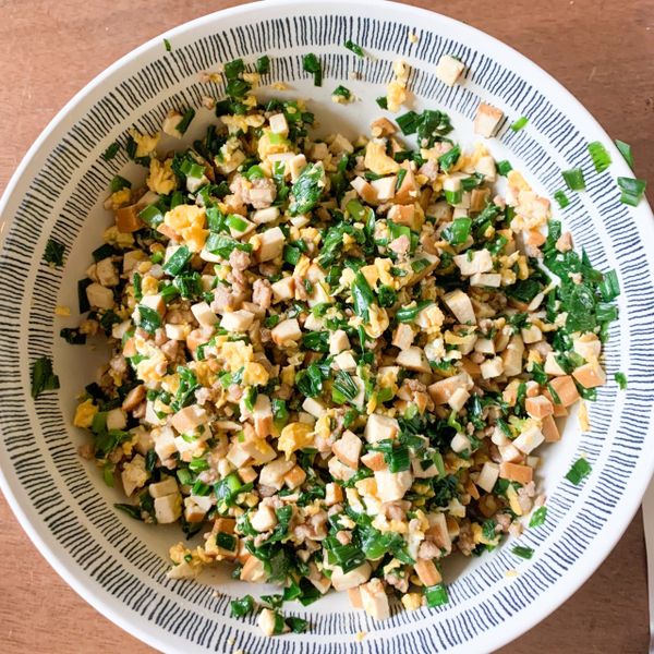 炒蛋熟後放小碗備用，開始炒其他的材料，豆干小塊塊噴點油下去炒炒，也是拿出來先備用，之後就換成韭菜了。

為什麼要先把韭菜炒熟，通常都是直接生的去拌餡，之後包好了才加熱不是嗎？

千張這個東西不耐久煎，所以裏頭包的東西最好是已經都熟了，不然非常考驗煎的技術歐。