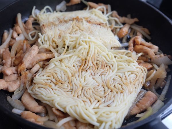 熱鍋：雞肉炒至半熟後加入油麵與醬油、鹽巴