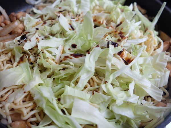 熱鍋：將麵拌勻後加入高麗菜與醋再炒3分鐘