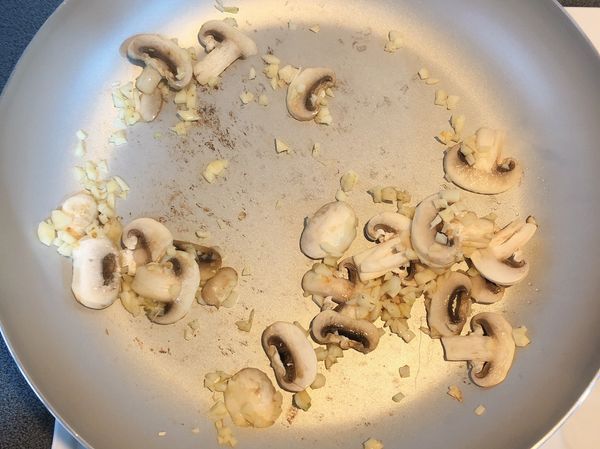 鍋內倒油，放入蒜末和蘑菇爆香