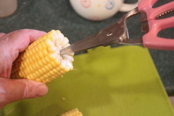 之前剝生玉米粒總是幾刀痛快切下去，雖然快速，但玉米粒殘殘破破、汁汁水水，總不是那麼歡喜。今天用另一個方法來剝。玉米去皮後折成兩段。