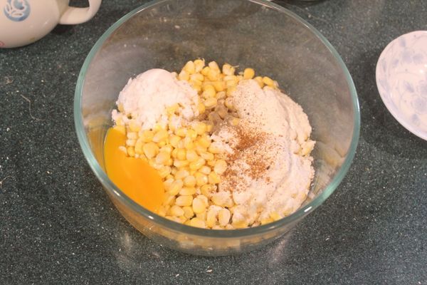 玉米粒和麵粉、太白粉、蛋黃、泡打粉、胡椒、鹽、七味粉和少許水放入小缽。