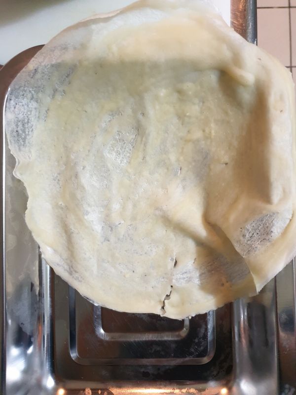 烙熟後，右手持筷，用左手和筷子取出備用