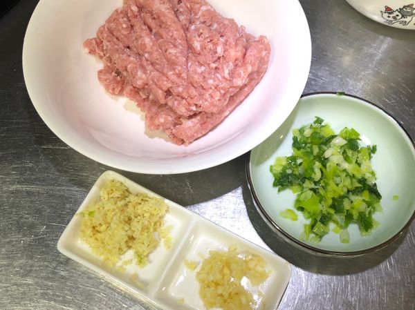 豬絞肉用菜刀剁出黏性，蔥、蒜頭跟薑切末