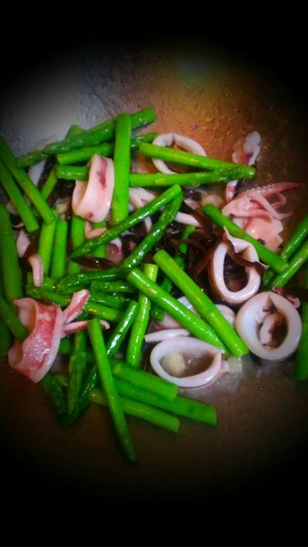 起鍋熱油，爆香蒜頭、黑木耳。
中大火快炒綠蘆筍約2分鐘，再下透抽、鹽，翻炒一下。
起鍋前淋些香油即可。
