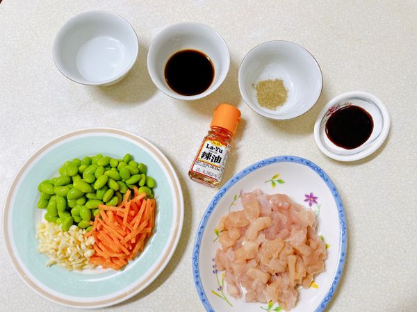 將把需要的食材備料完成，比較不會手忙腳亂喔！
雞里肌切丁、毛豆去殼、紅蘿蔔切絲、蒜頭切末。
-
毛豆可以選擇冷凍即食毛豆蠻方便的，稍微用水浸泡後就能輕鬆將毛豆取出喔！
