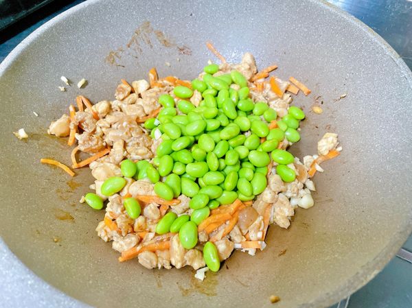 毛豆下鍋拌炒到雞丁到熟。