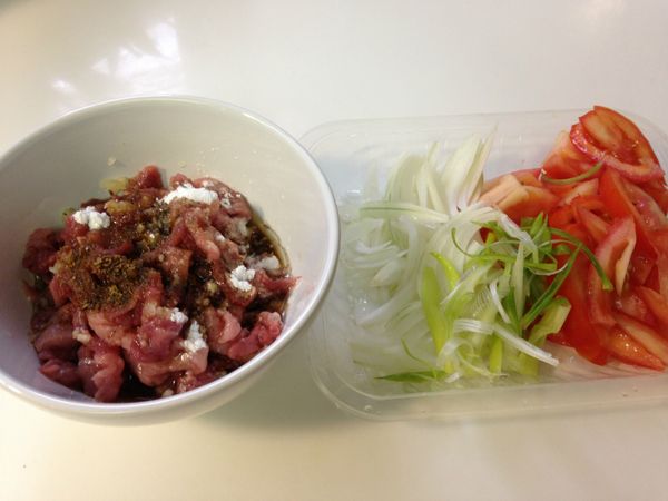 備料。蕃茄切成薄片，洋蔥切細絲。[醃料]加入肉絲中靜置入味備用。