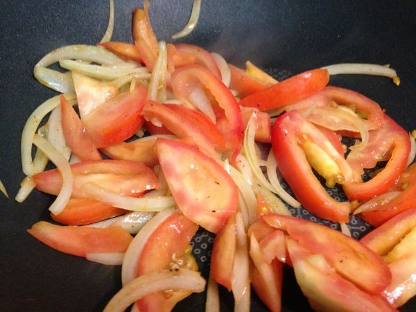 同一鍋依序下洋蔥和蕃茄片炒香。