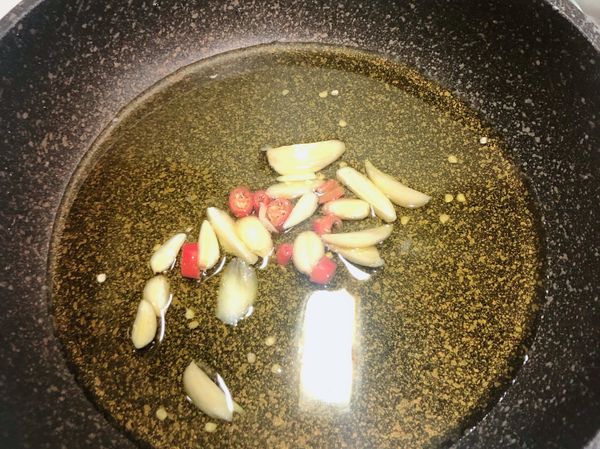 中小火加橄欖油煸蒜和辣椒，至蒜旁開始冒油泡，下香菇煎、兩面炒一炒，至香味冒出，鍋子需不停晃動防蒜焦