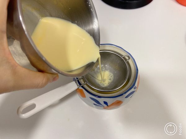 將蛋液隔篩倒入容器。