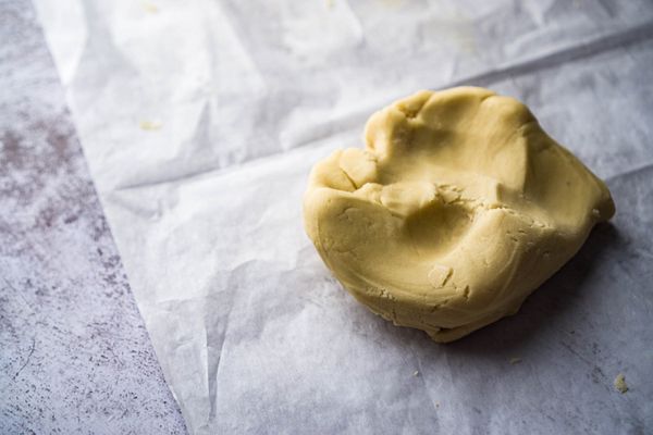 把麵團倒到桌面上，搓圓，撒上一點麵粉，把麵團擀平成大約3-4毫米的厚度；