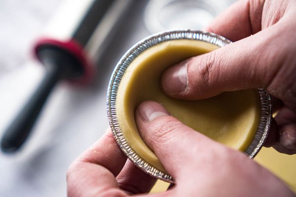 把撻皮放到蛋撻模具上，輕輕按到貼服就可以了，都做完了就送到冰箱裡靜置；