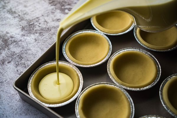 過篩，是做出細膩的蛋撻餡的關鍵。過篩可以把一些雞蛋裡的筋膜和雜質曬走，灰常灰常重要！做好的蛋撻水加上保險膜後放到冰箱裡，靜置最少2個小時；靜置好後，組合蛋撻水和蛋撻皮。烤爐預熱220C（450F）。不像酥皮在烘烤的時候會先收縮再膨脹，曲奇皮沒有這個顧慮，所以可以把蛋撻水加到9分滿也沒關係。