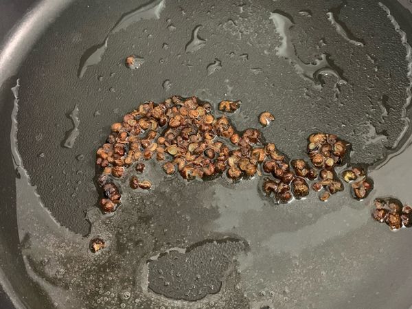 先將花椒和油煸香，把香氣逼出後濾出花椒粒