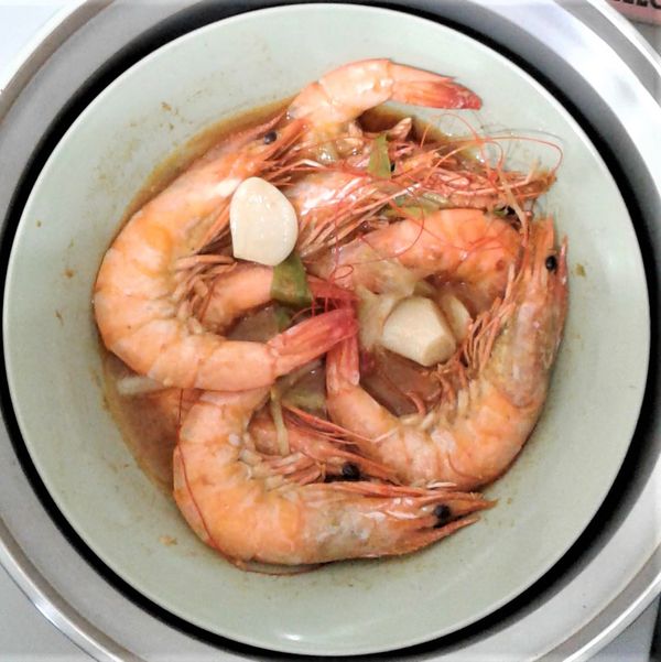 打開步驟三的電鍋蓋，將盤內的大白蝦上下翻面後，加入1湯匙的沙茶醬和2小匙海鹽攪拌均勻；外鍋再加入2刻度量米杯的水，按下開關，煮約7分鐘跳起，悶5分鐘。
