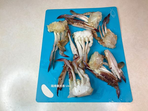 螃蟹洗淨後用刀背把蟹殼敲裂。