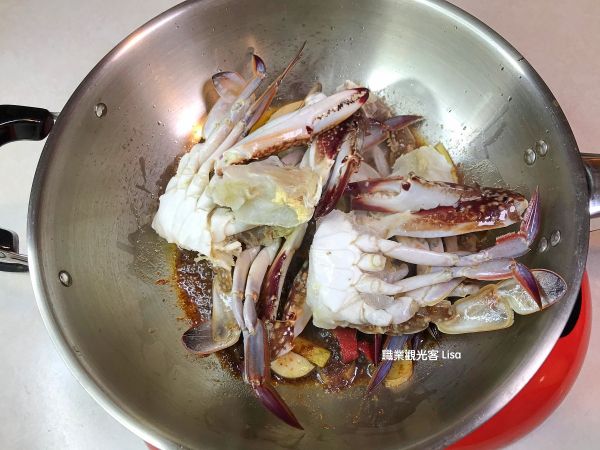 放入螃蟹翻炒，接著加入糖、醬油、米酒、蠔油、辣豆瓣醬及水，翻炒過後蓋上鍋蓋悶10分鐘。