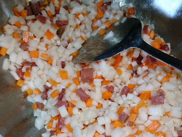 火腿炒出鹹香味再放入紅白蘿蔔丁翻炒。