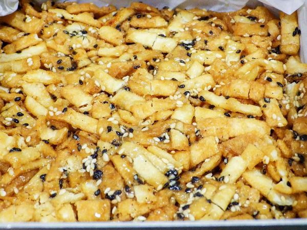 容器裡舖上一張烘培紙把攪拌好的餃子皮倒入再壓緊壓實