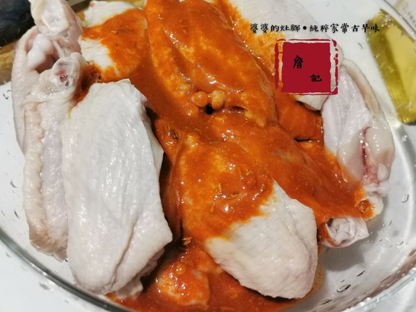 紐奧良辛香料跟辣醬還有開水攪拌均勻倒入盆裡的翅中。