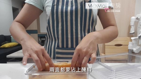 把鱈魚放入盒子裡，兩遍都沾上醃料。
