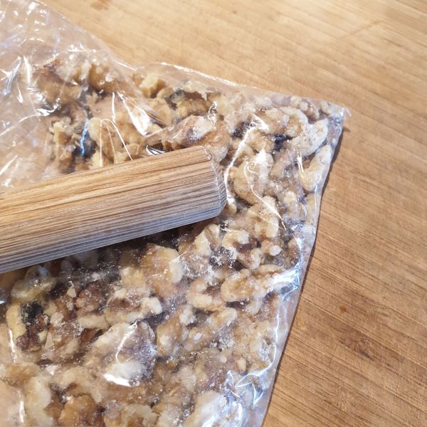 將核桃放入保鮮袋中用桿麵棍敲碎。