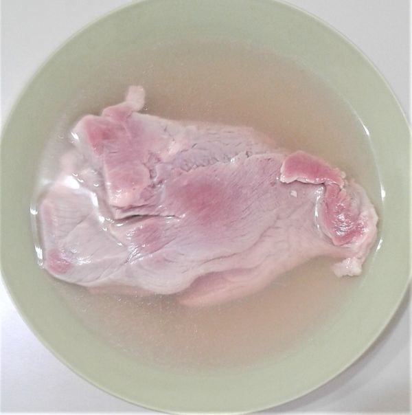 先將豬胛心肉塊用熱水川燙過後，加入2湯匙米酒備用。