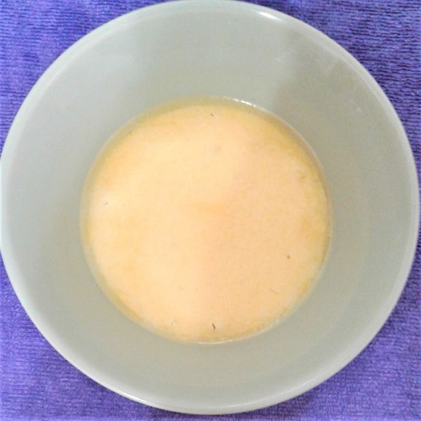 取一深碗，打入一粒雞蛋，再舀入12湯匙的麻油豬肉湯，用筷子將蛋汁攪拌均勻；外鍋放入量米杯5刻度的水，再按下電鍋開關，煮約15分鐘跳起，悶10分鐘，「麻油蒸蛋」上菜囉!