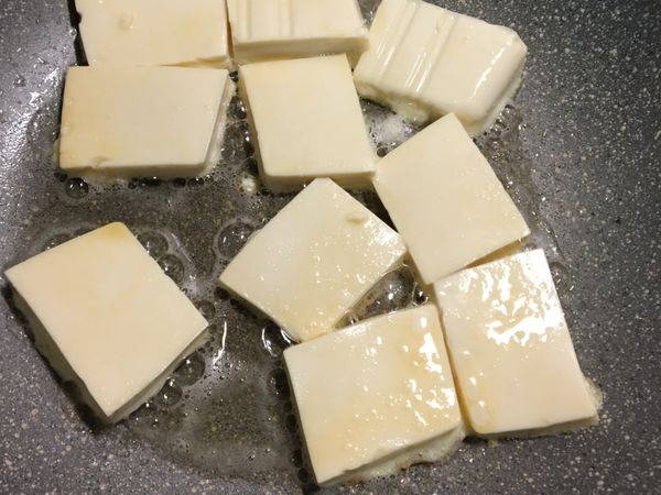 鍋裡放2大匙油，油熱放入裹上蛋液的豆腐，一面煎成金黃色後小心翻面續煎成金黃色⋯
煎好後盛起來備用。
我沒買到板豆腐，用板豆腐會更好煎。