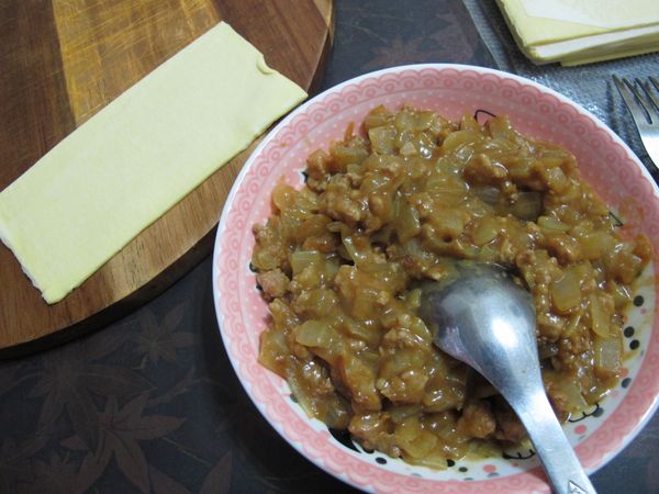 將酥皮切成一半，再將咖哩肉將包覆在酥皮內