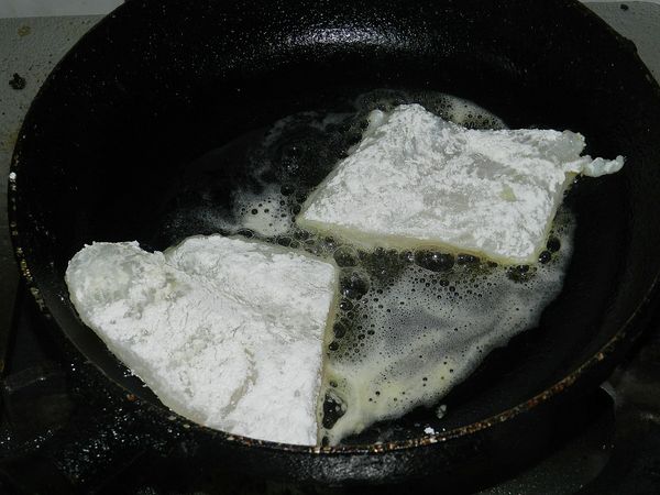 起一油鍋，將沾麵粉的魴魚下鍋煎金黃